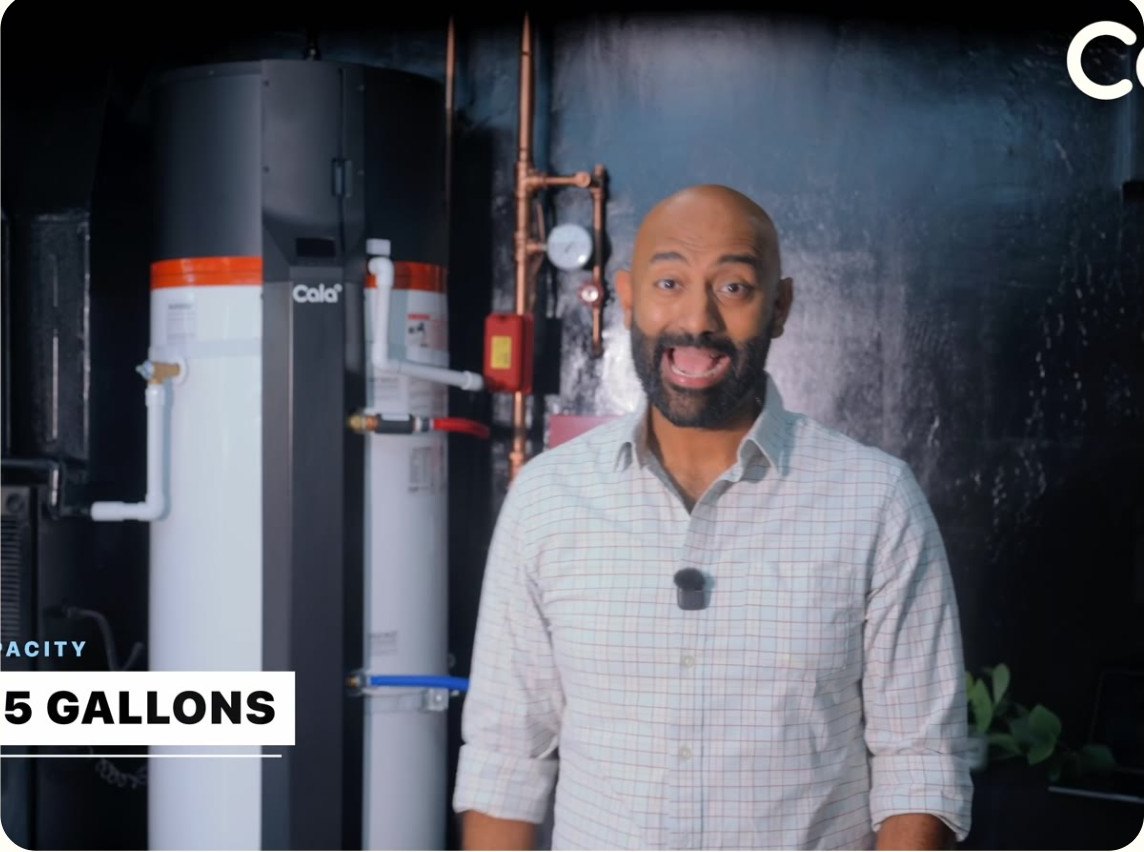 Ricky of Two Bit da Vinci standing beside a Cala heat pump water heater
